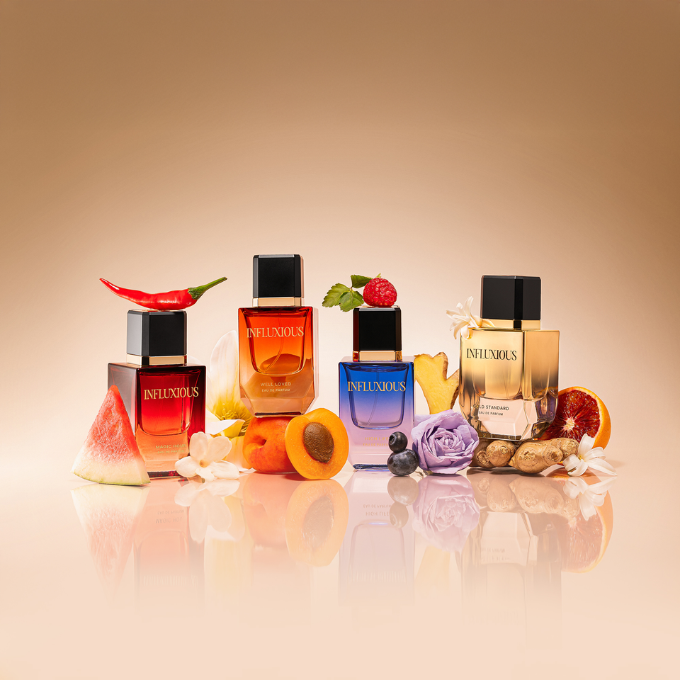 Four perfume bottles arranged with fruits flowers and spices