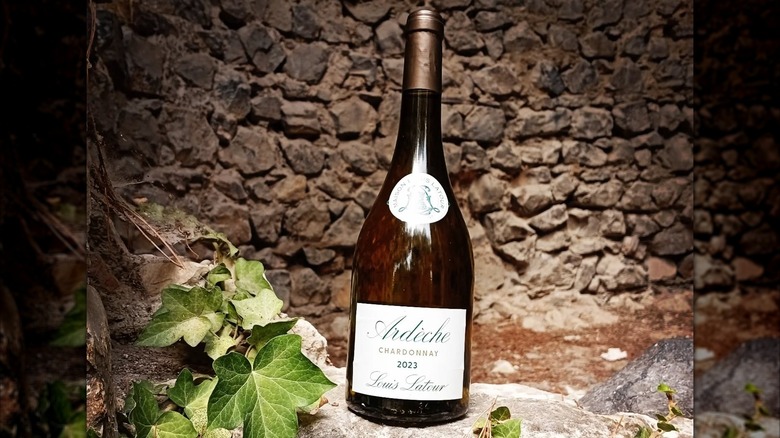 bottle of white wine in front of stone wall
