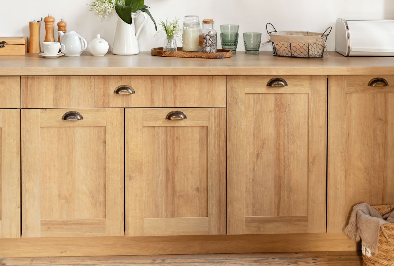 Wooden kitchen cabinets with a countertop displaying kitchen items
