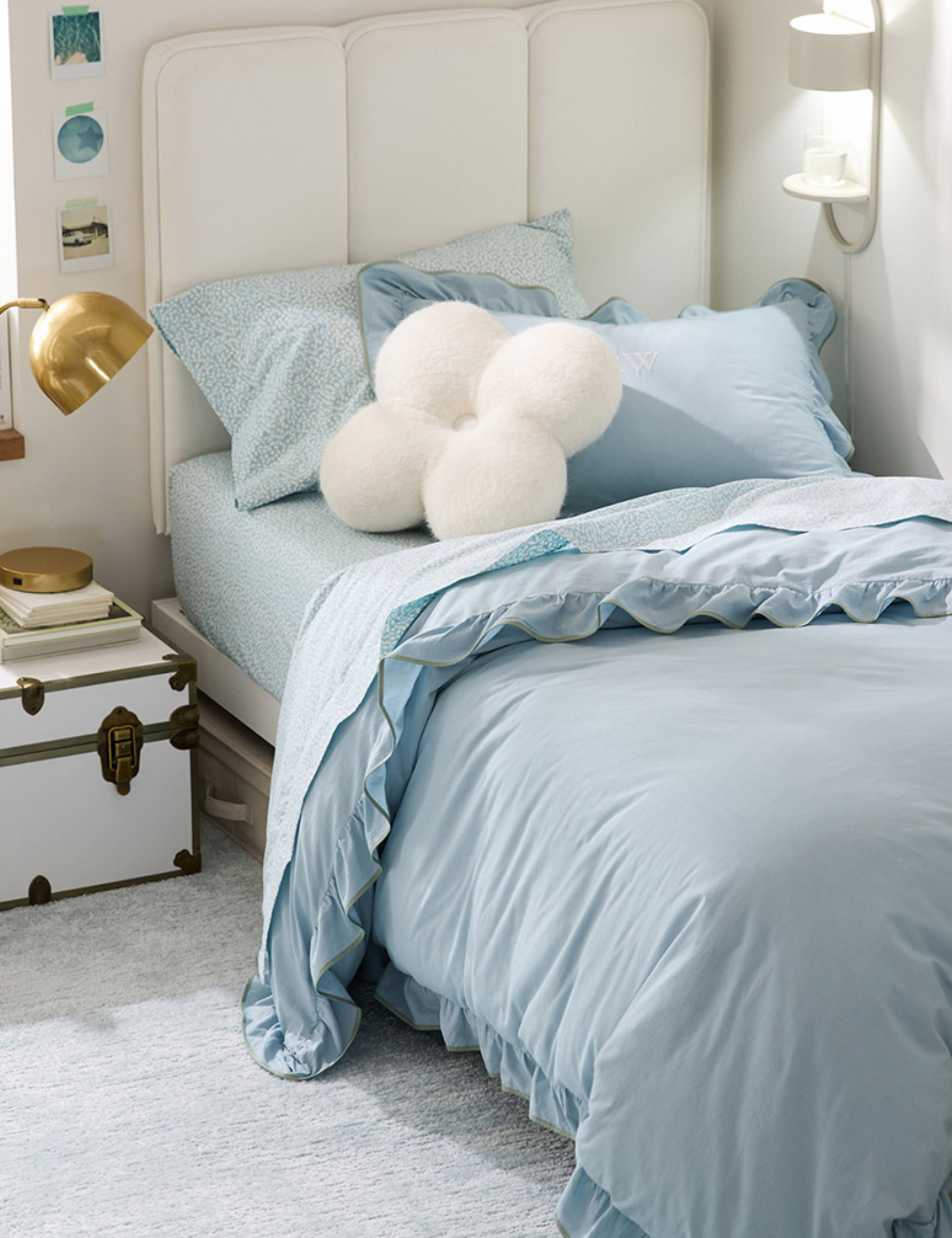 Soothing dorm room featuring sea blue bedding and a floral accent pillow