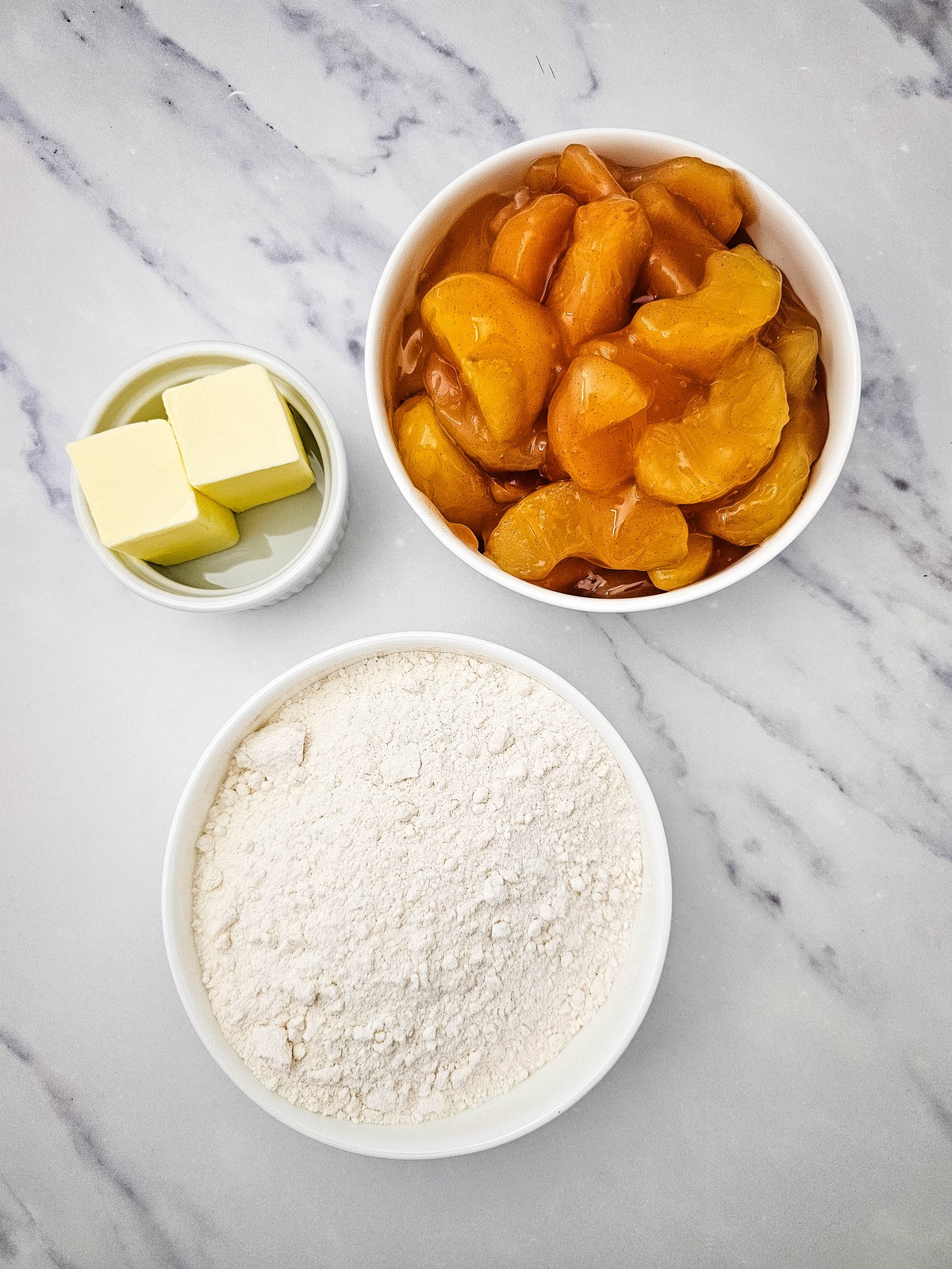 Three ingredients for apple dump cake: apple pie filling, yellow cake mix and butter