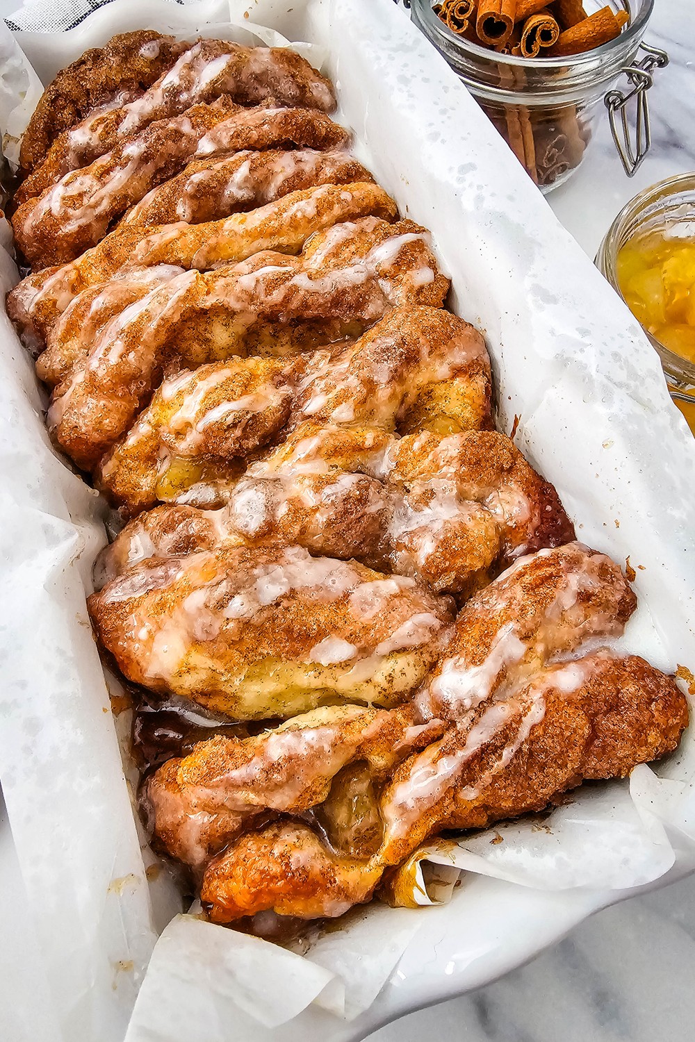 Apple cinnamon biscuit loaf pull apart bread in a loaf pan with glaze