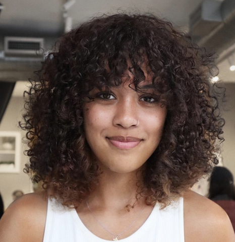 Woman with curly hair fringe cut