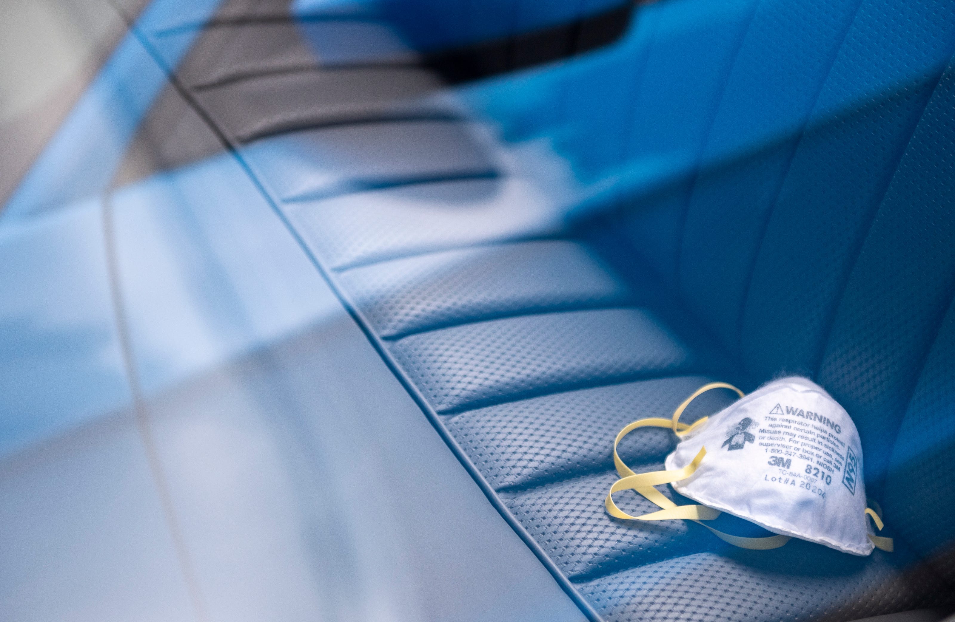 An N95 face mask rest in the back seat of a vintage Mercedes-Benz that's parked inside the Pasadera Golf & Country Club in Monterey, Calif., on Thursday, Aug. 5, 2021.