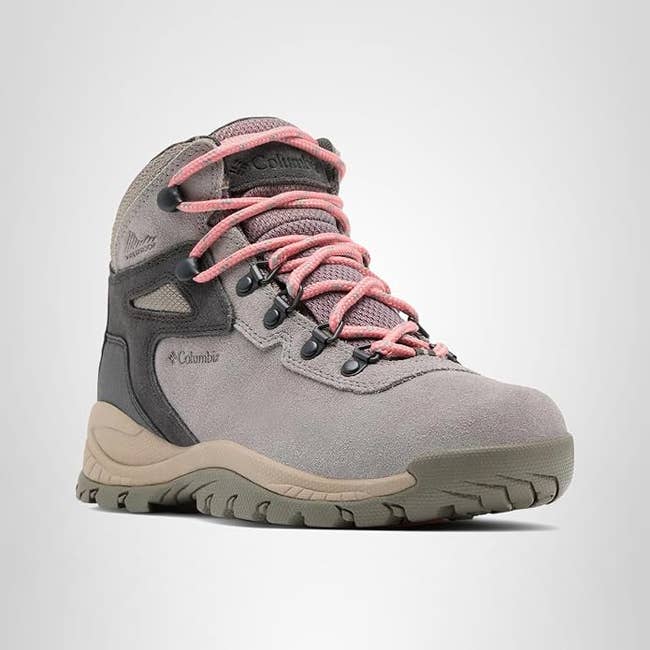 A gray hiking boot with pink laces, featuring a durable sole and ankle support, ideal for outdoor adventures