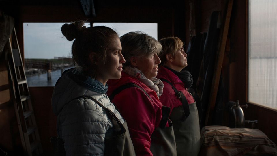 Chiara Vallati with her mother, Barbara Tesserin, and her aunt, Giovanna Tesserin, in their family boathouse. Trained as a chef, Chiara returned to clam fishing during the Covid-19 pandemic when restaurants were closed. Barbara and Giovanna became fisherwomen in the 1990s, following their mother, one of the first women in the area to fish. In 2024, the family gave up their fishing license after invasive blue crabs destroyed local clam beds. - Chiara Negrello