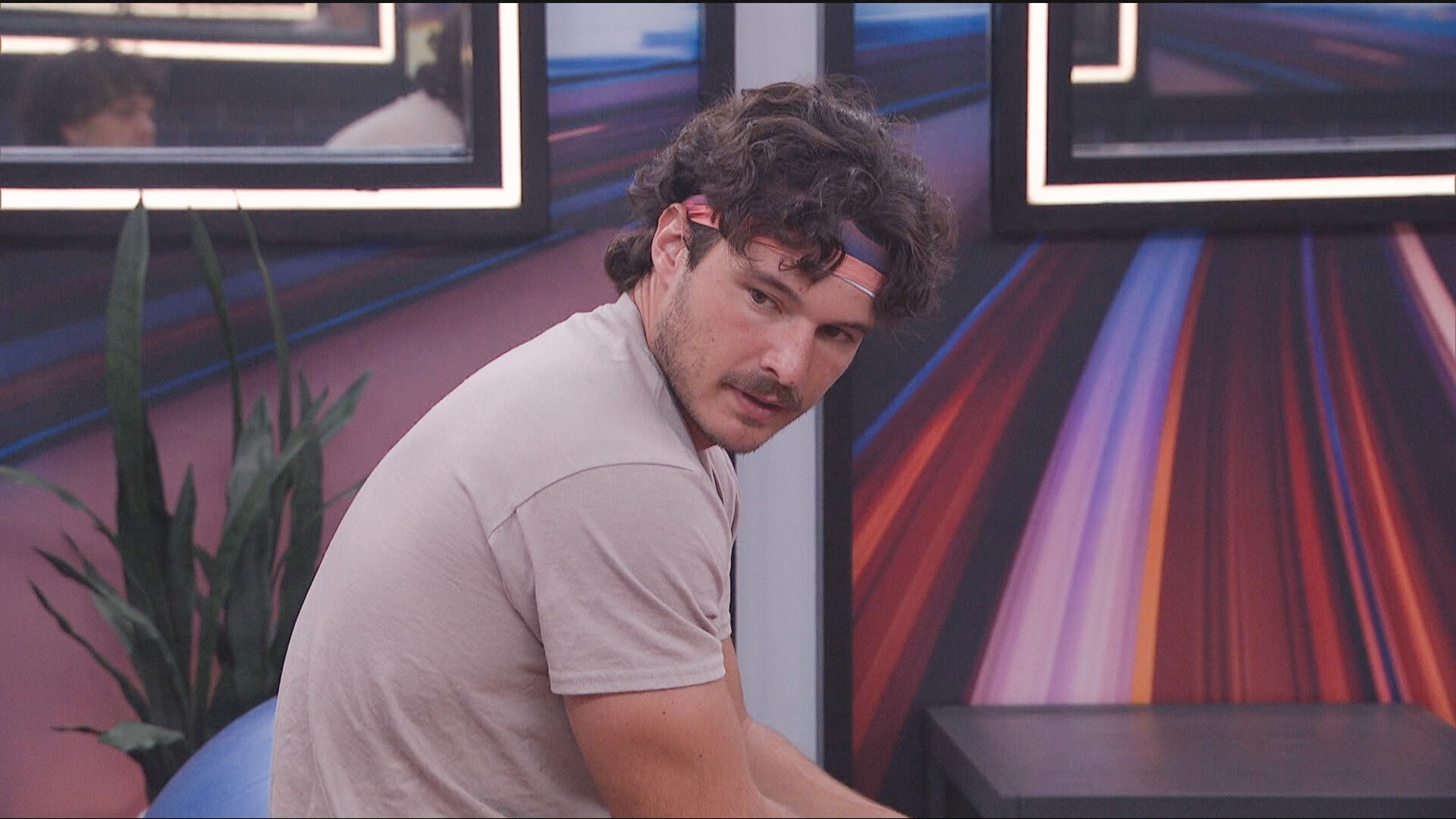 Rome Seymour looks over his shoulder as he sits in a bedroom on 'Big Brother 28'