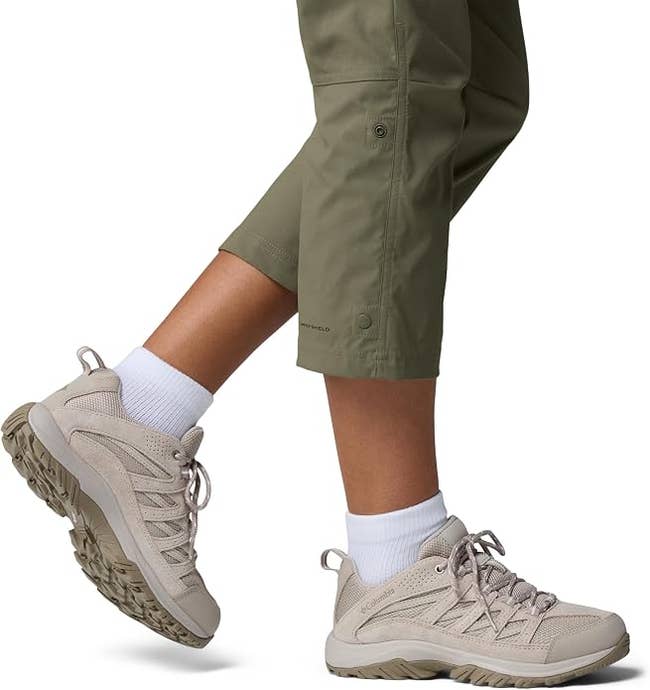 Person wearing lightweight hiking shoes and cropped outdoor pants, showcasing footwear suitable for trail walking or casual wear