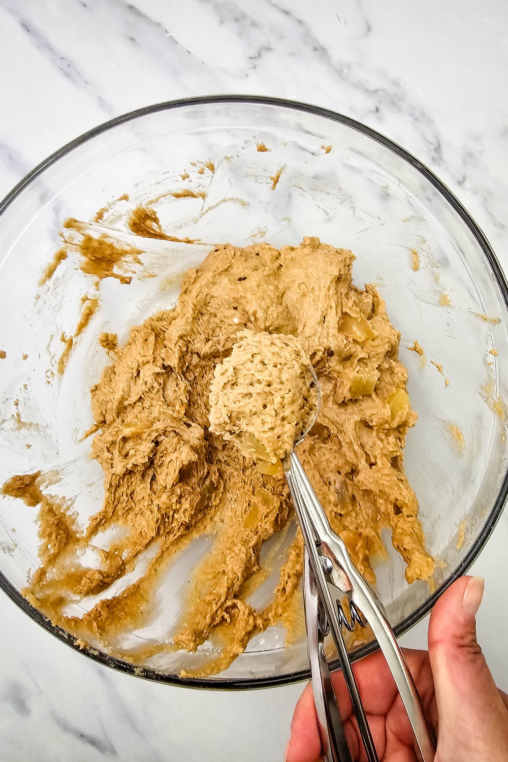 Scooping soft apple cookie dough with a cookie scoop