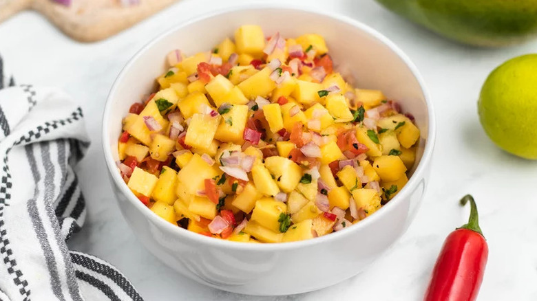 Fresh mango salsa in white bowl on countertop