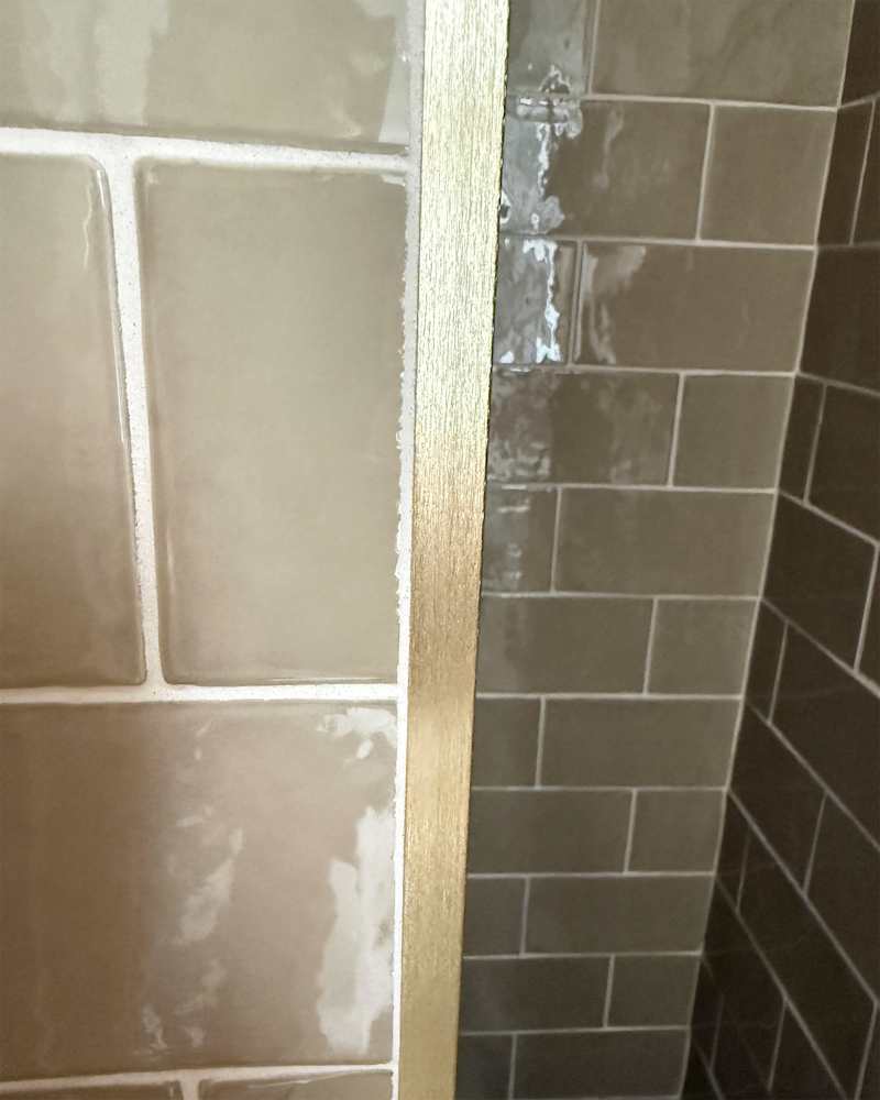 Green-grey subway tiles in bathroom.
