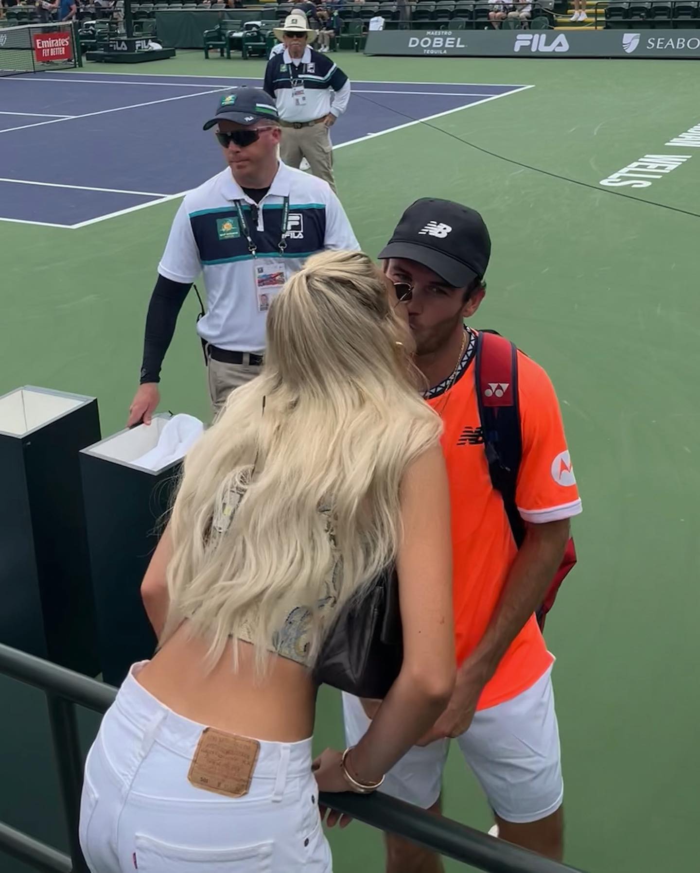 Paige Lorenze kissing Tommy Paul at a tennis event.