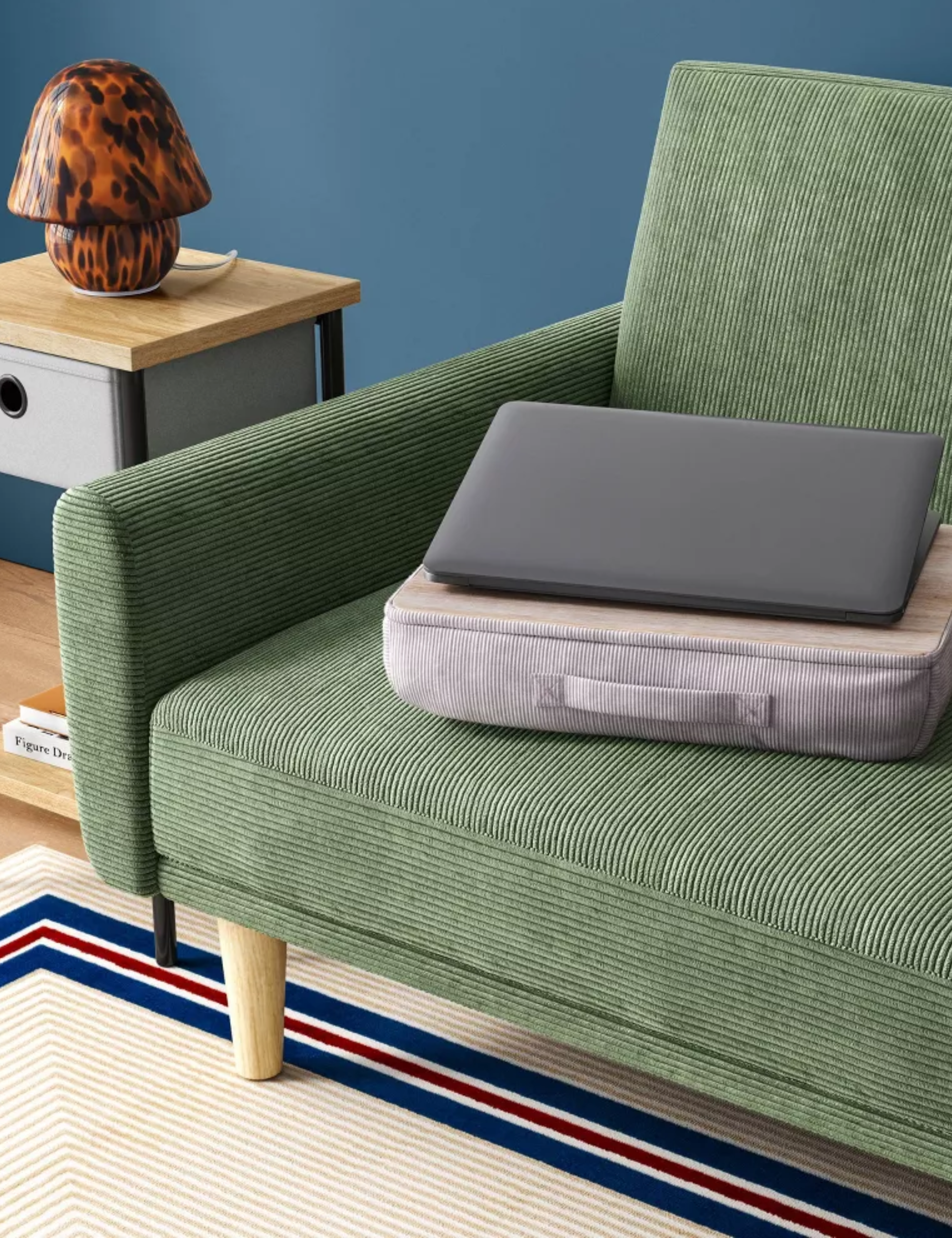 Dorm room lap desk sitting atop a hunter green couch
