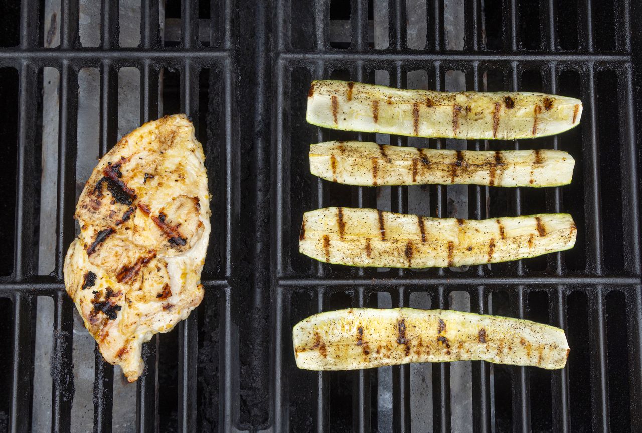Grilled chicken breast and zucchini slices on a grill