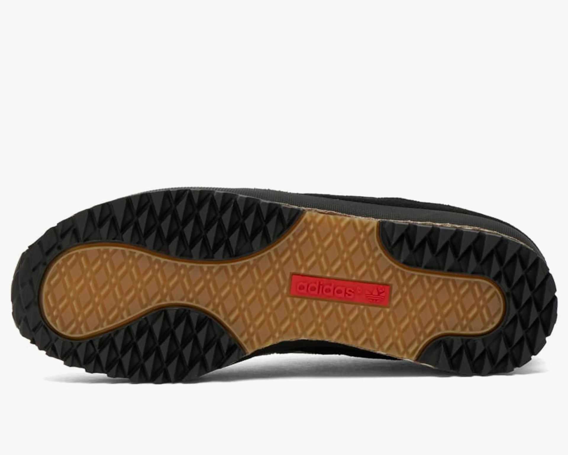 Black and gum rubber Adidas shoe sole with red Adidas logo in the center.