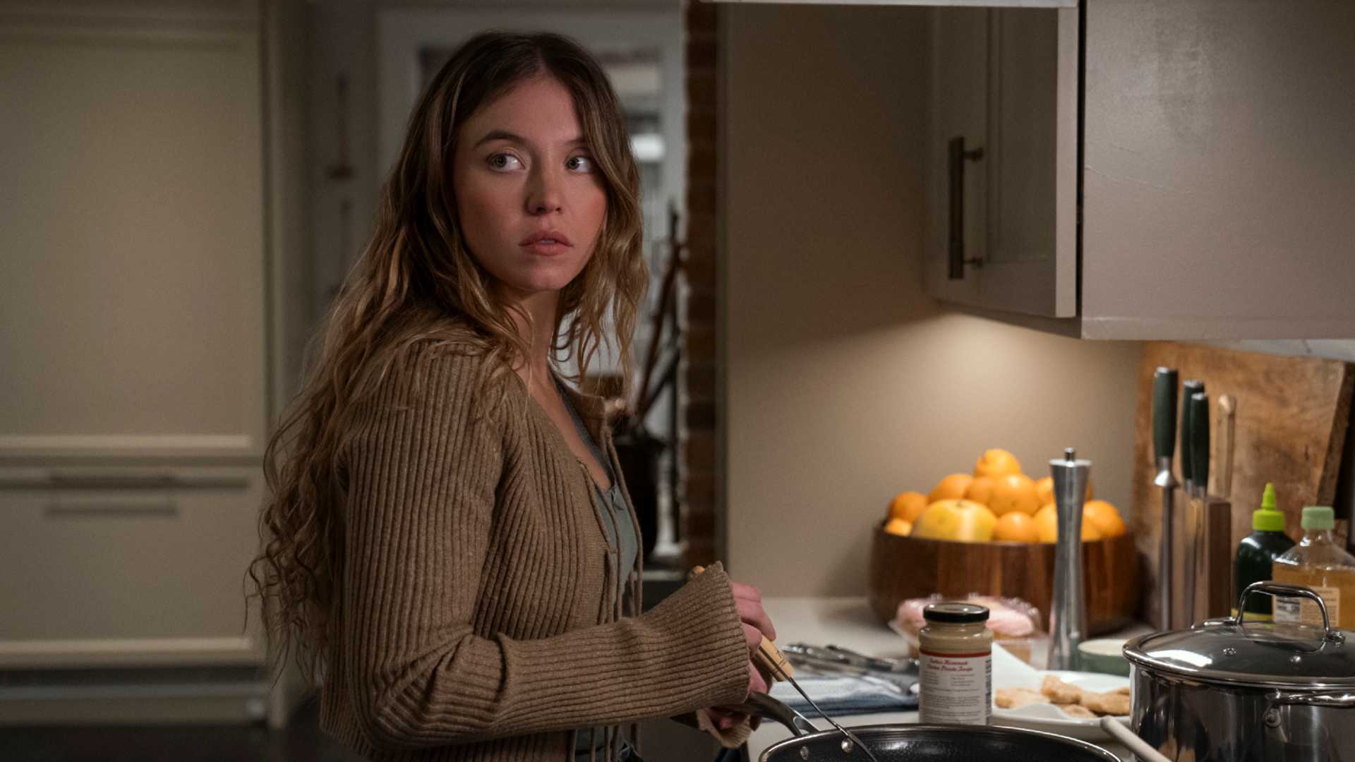 Sydney Sweeney cooking in The Housemaid