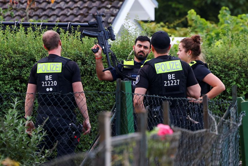 Police officers secure the area at an allotment garden complex in the Berlin suburb of Spandau after a known Islamist, suspected of ramming a minivan into a crowd near Berlin's annual Christopher Street Day Pride parade on Saturday evening, was shot and killed in a police operation, in Berlin, Germany, July 26, 2026. REUTERS/Christian Mang