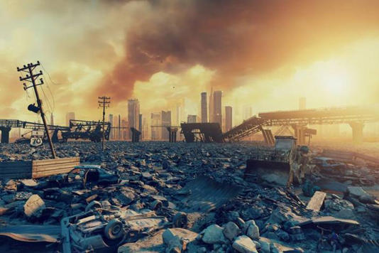 An aerial view of a devastated cityscape is depicted. In the background, several ruined buildings emit plumes of smoke, suggesting a catastrophic event. The foreground is cluttered with debris and rubble, and an electrical pole stands amidst the wreckage. The sky above is overcast, with the setting sun casting a warm, hazy light over the scene.