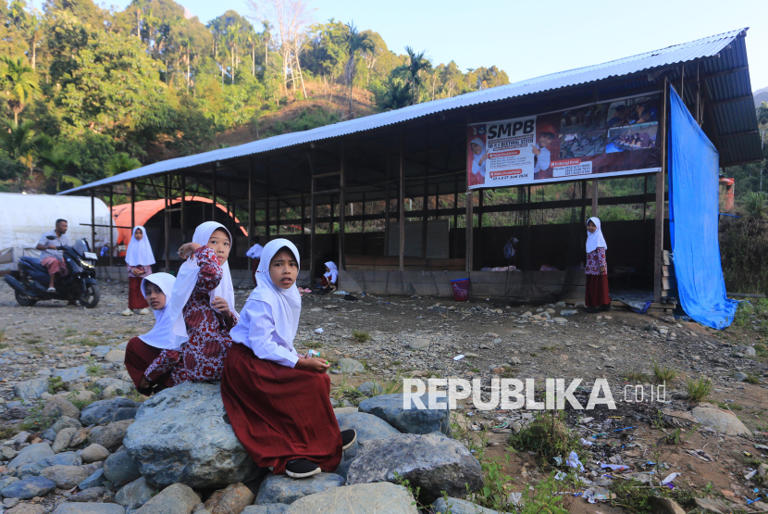 Sejumlah siswa berada di halaman ruang kelas Sekolah darurat Sekolah Dasar Negeri (SDN) 1 Beutong Ateuh Banggalang, Desa Kuta Teungoh, Nagan Raya, Aceh, Kamis (23/7/2026). Sebanyak 125 siswa terpaksa belajar di ruang kelas darurat yang terbagi tiga ruangan dan digabung enam kelas akibat bangunan sekolah mereka rusak pascabencana banjir bandang yang terjadi akhir November 2025 lalu.