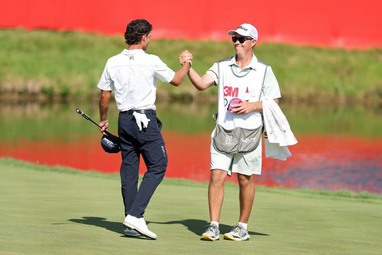 Jackson Koivun and caddie David Flynn celebrate on the 18th green