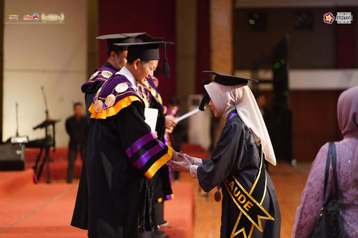Rektor Universitas Amikom Yogyakarta, Prof. Suyanto, memindahkan tali toga Devi Setyo Wihastuti sebagai penanda kelulusan dalam prosesi Wisuda Periode ke-99 di Grand Pacific Hall & Convention Center, Sabtu (25/7).