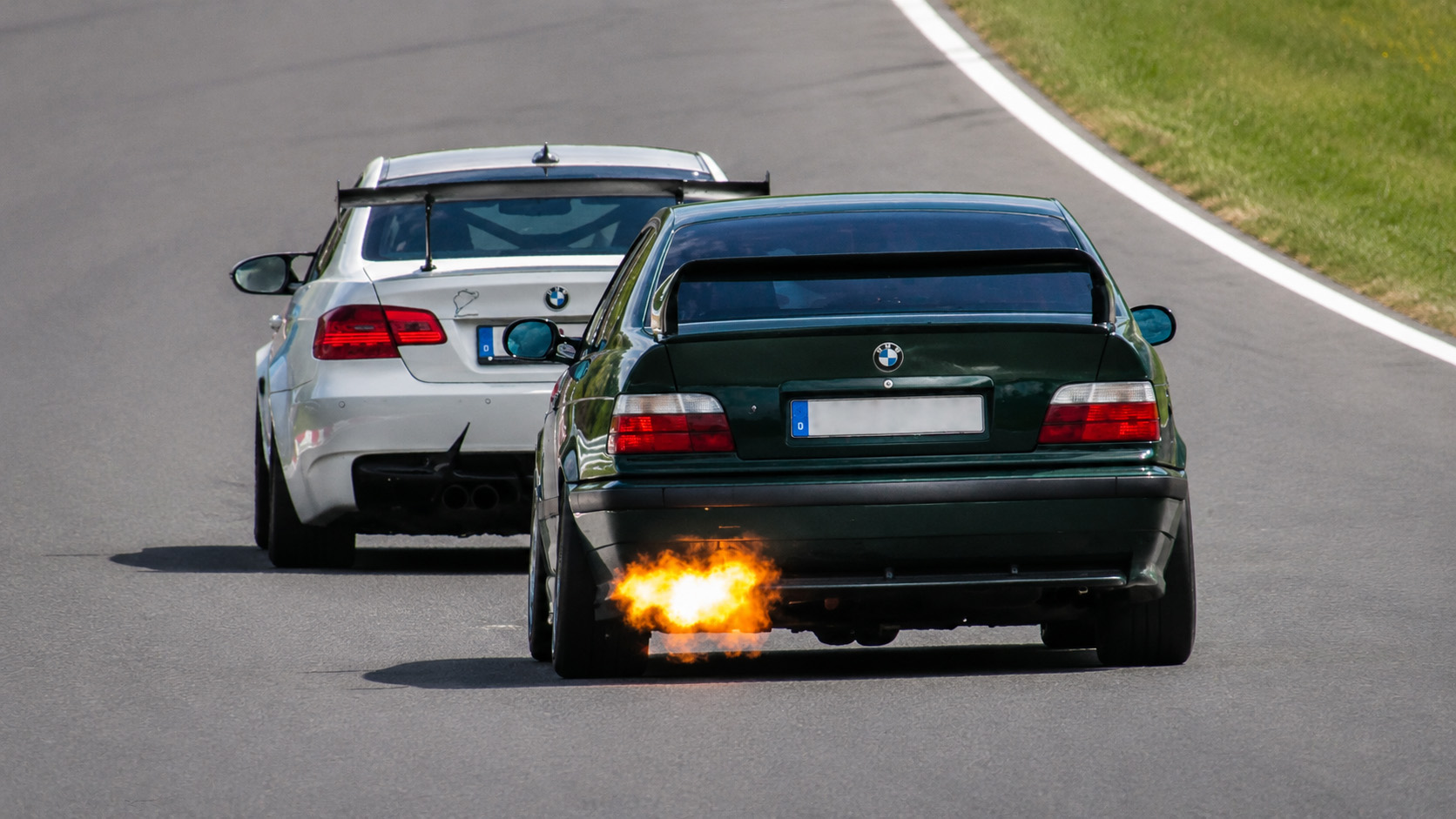 Modified BMW E36 shoots flames during a tight track battle