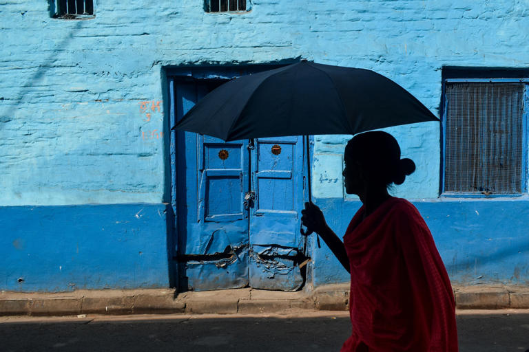 Una mujer está usando un paraguas mientras camina por la calle durante un día muy caluroso de verano en Calcuta, India, el 9 de abril de 2023. (Foto de Sudipta Das/NurPhoto vía Getty Images)