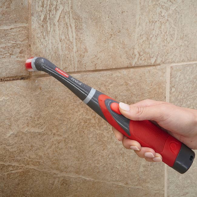 someone scrubbing tile grouts with the scrubber