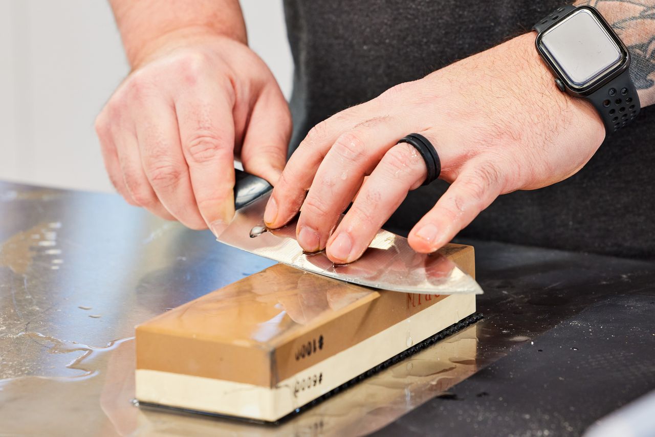 a person sharpening a knife using Mizuyama Sharpening Stone