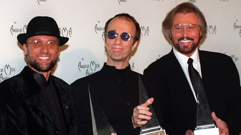The Bee Gees in black suits and sunglasses, 1997