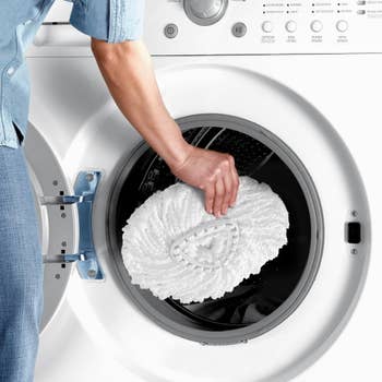 someone throwing the mop head into a washing machine