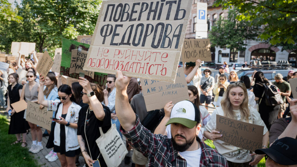 Protesters holding handmade signs in Ukrainian, including one reading