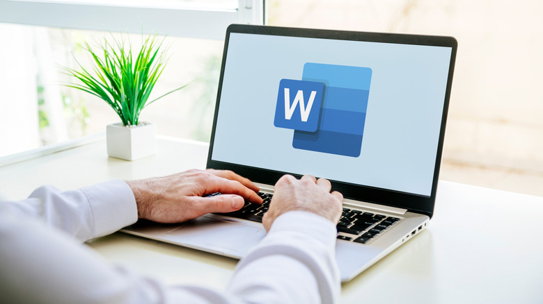 A man using a laptop with the Microsoft Word logo on the screen