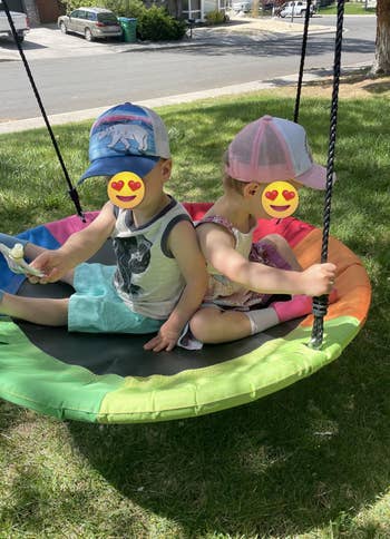 two toddlers on the swing