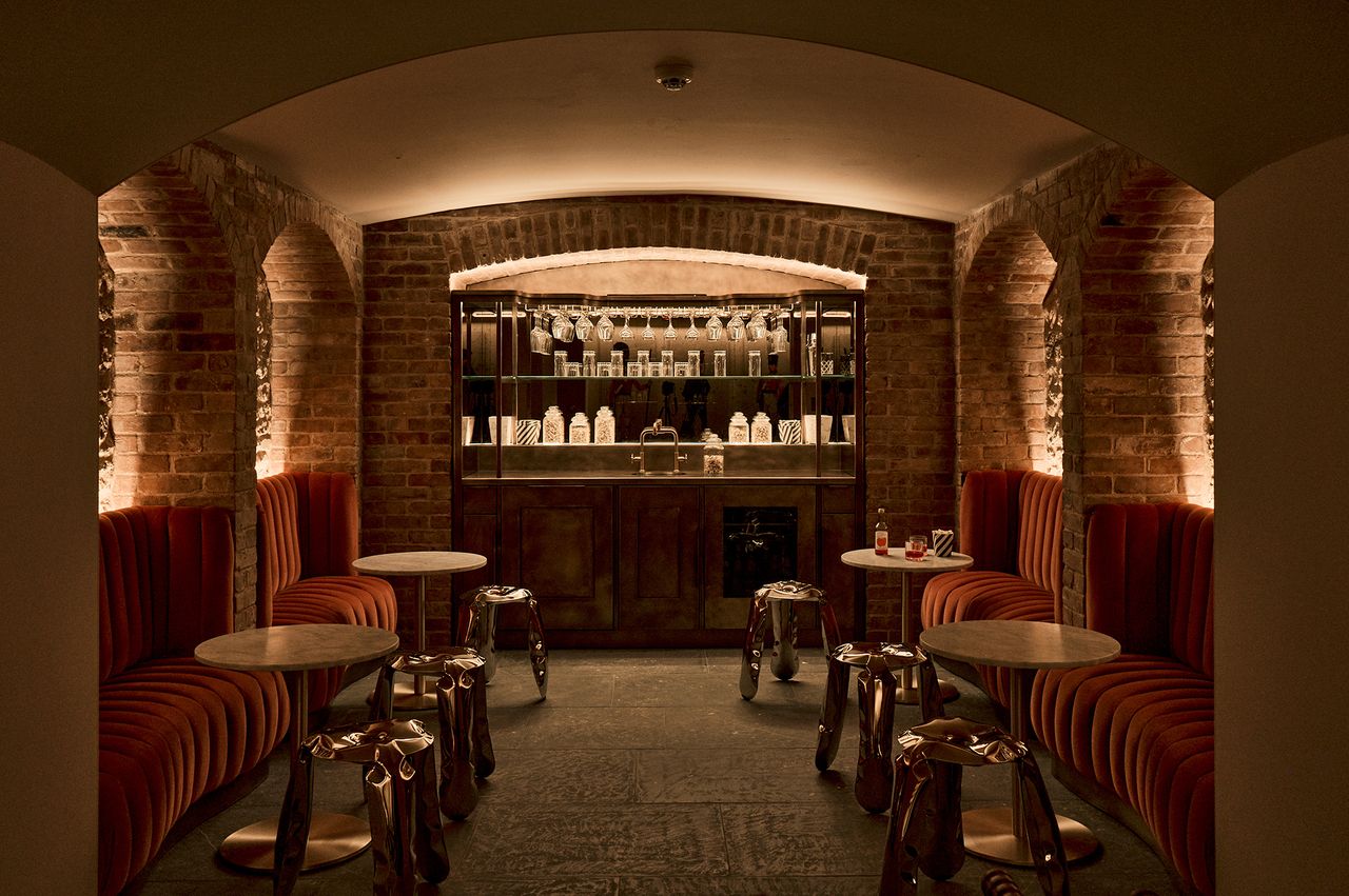 Cozy seating arrangement in a brickwalled bar area with tables and stools