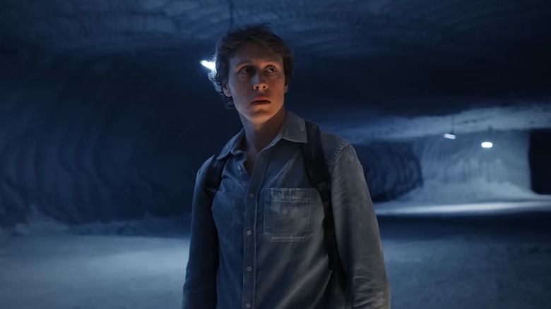 Son walking through the frozen underground cave where his family lives in The End