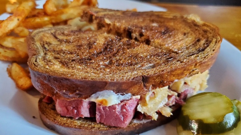 Blackstone Reuben with side of French fries and mini pickle slices from Crescent Moon Alehouse