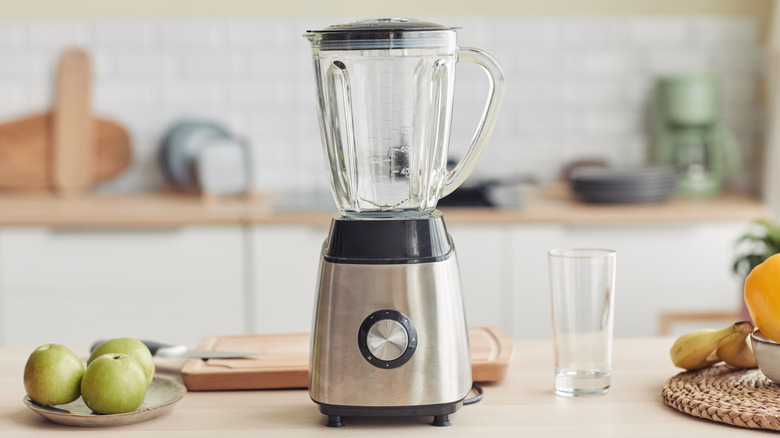 An empty stainless steel blender with a glass pitcher, displayed on a kitchen counter