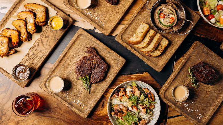 Top view of steaks and various dishes on a table