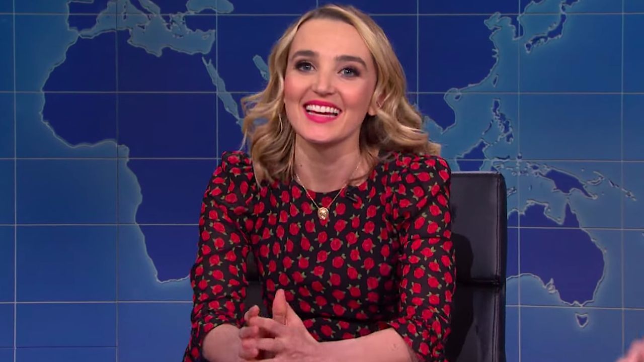 Chloe Fineman smiling at the SNL Weekend Update desk