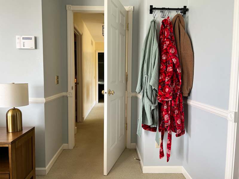 Robes hung on rack in bedroom.