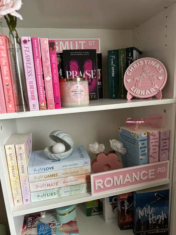 Bookshelves with romance novels and modern decorations, including signs reading
