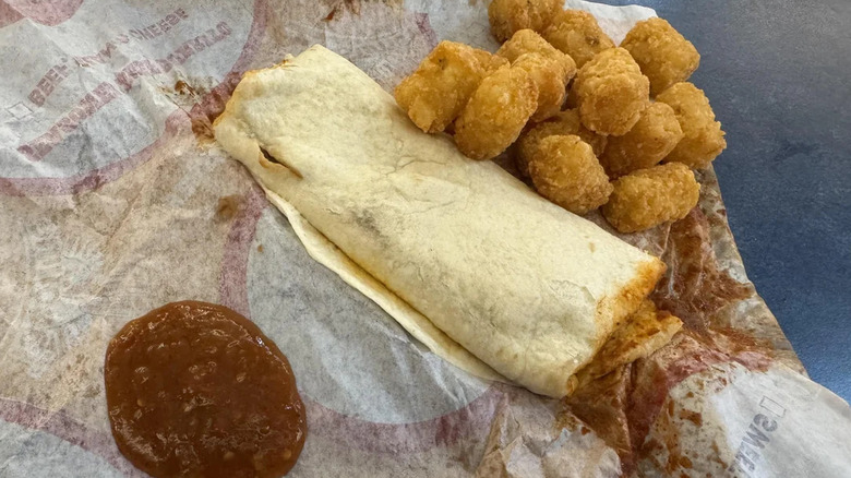 Burrito with potato tots on sauce on TacoTime open packaging