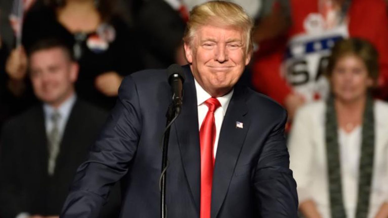 Donald Trump smiles as he pauses during a speech at a
