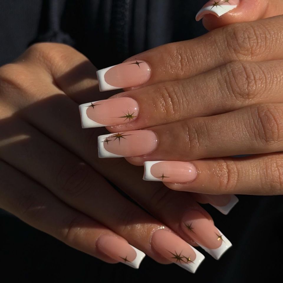 Hands displaying manicured nails with intricate nail art design