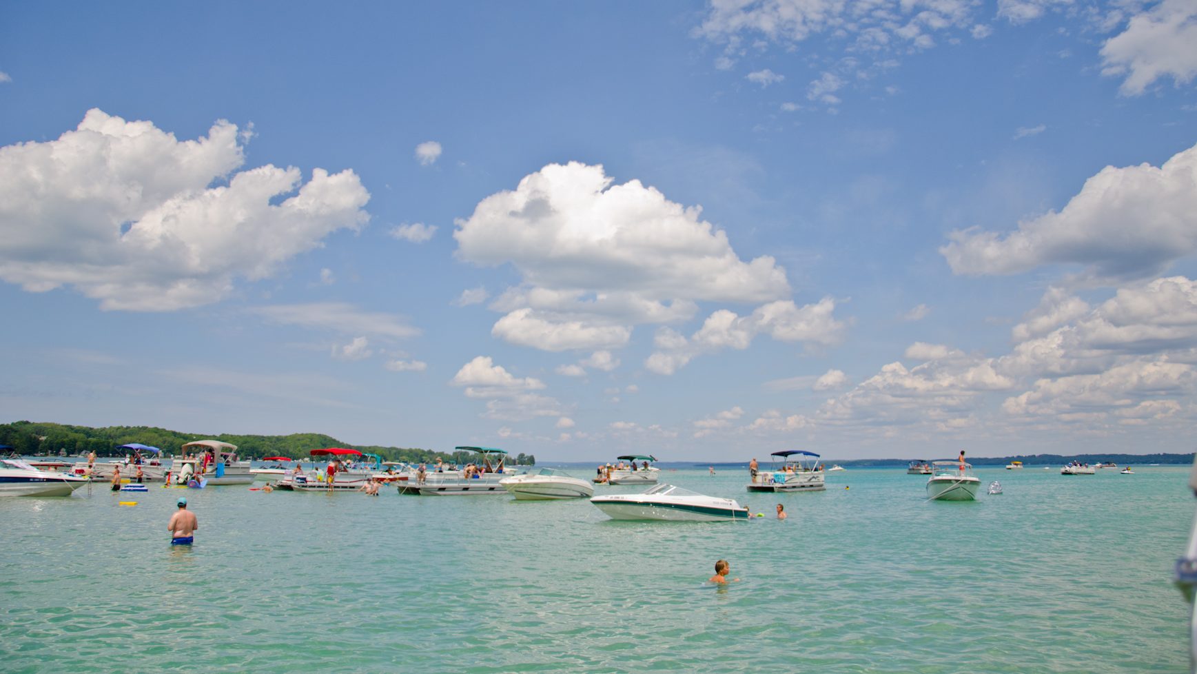 The clear, blue waters of Torch Lake in Michigan with boats on the water.