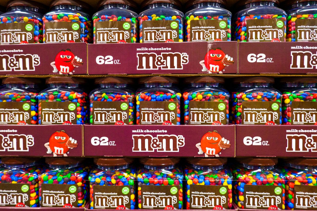 Shelves stacked with jars of MMs milk chocolate candies