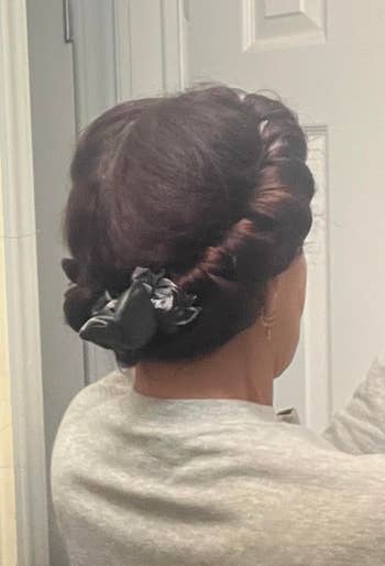 reviewer with hair wrapped around a heatless curling rod secured with scrunchies