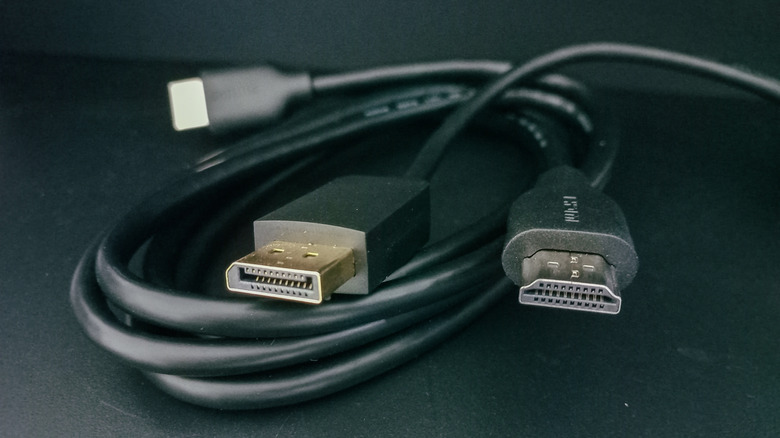 An HDMI cable and DisplayPort cable tangled together