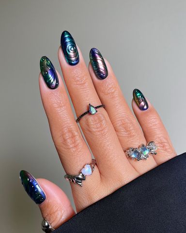 Hand with intricate nail art and multiple rings